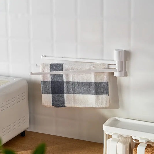 White three-arm wall towel rack holding a hand towel