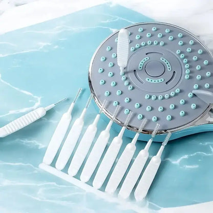10-piece white mini shower nozzle cleaning brush set beside a shower head