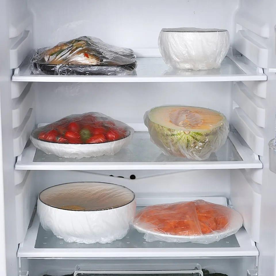 Elastic food covers used on bowls and plates inside a refrigerator