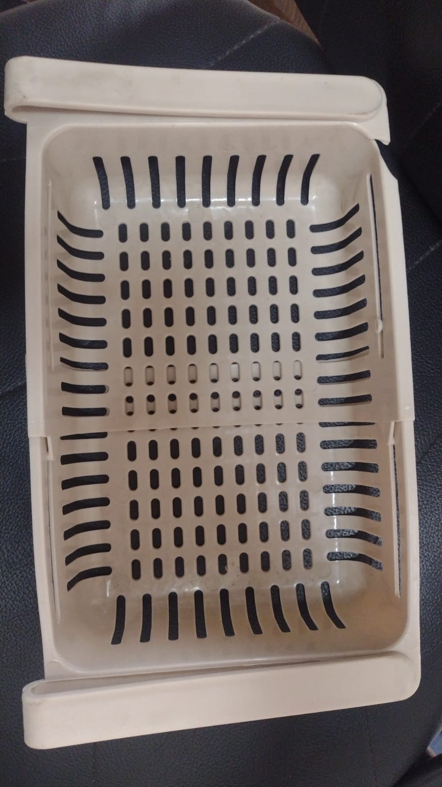 Close-up of adjustable plastic hanging fridge basket with sliding side rails