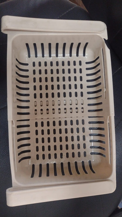 Close-up of adjustable plastic hanging fridge basket with sliding side rails
