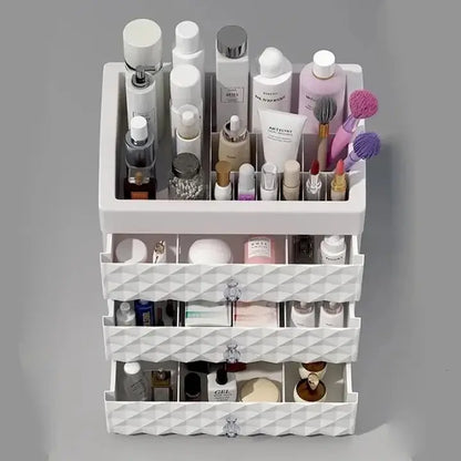 Front view of white makeup organizer showing top compartment and three partially open drawers
