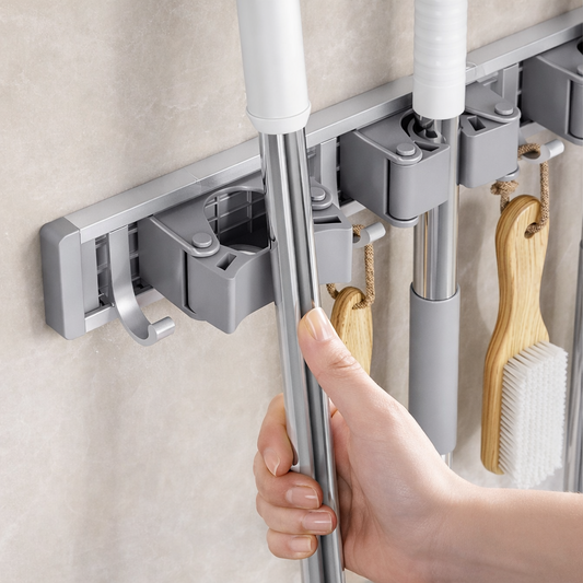Wall-mounted mop and broom holder securing cleaning tool handles