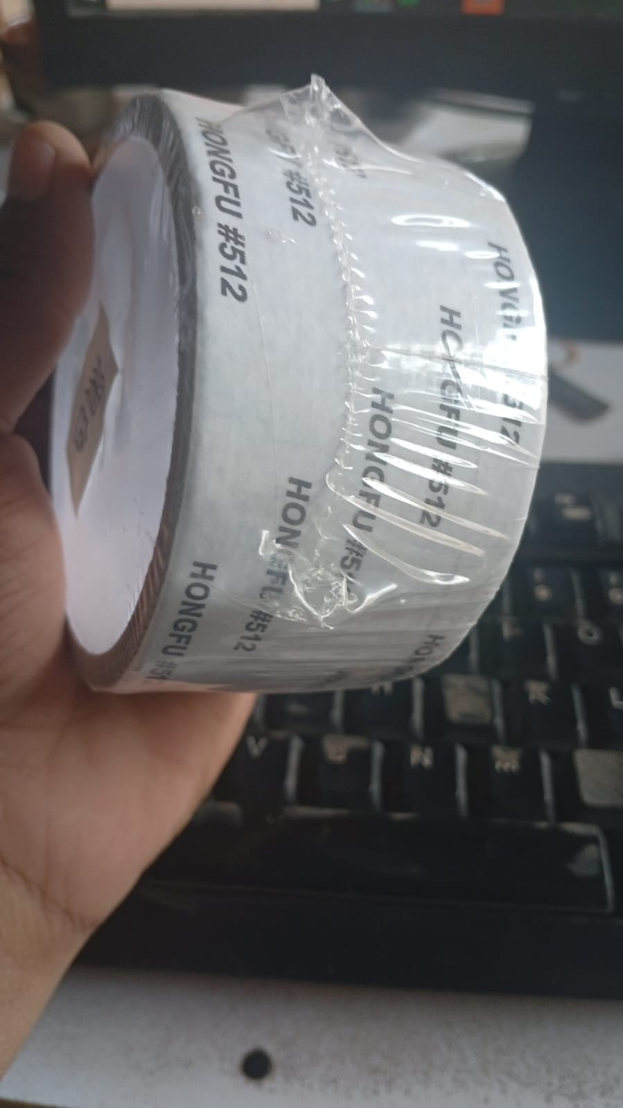 Close-up of a self-adhesive mesh window screen repair tape roll