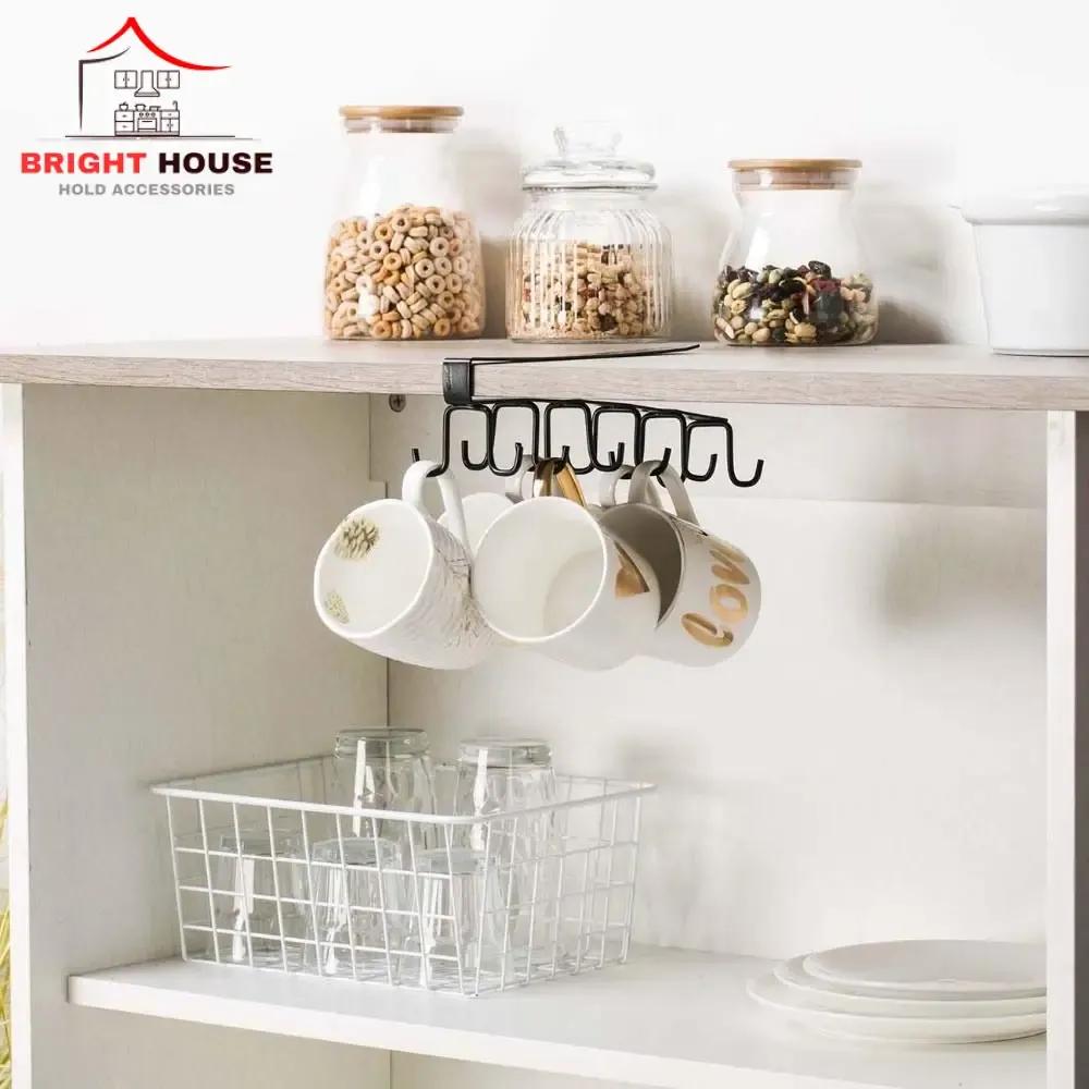 Black under-shelf mug holder rack with mugs hanging in a kitchen cabinet